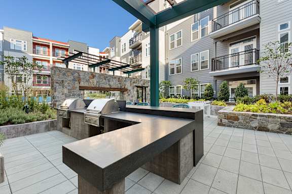 A modern outdoor kitchen area with a long counter and grill.
