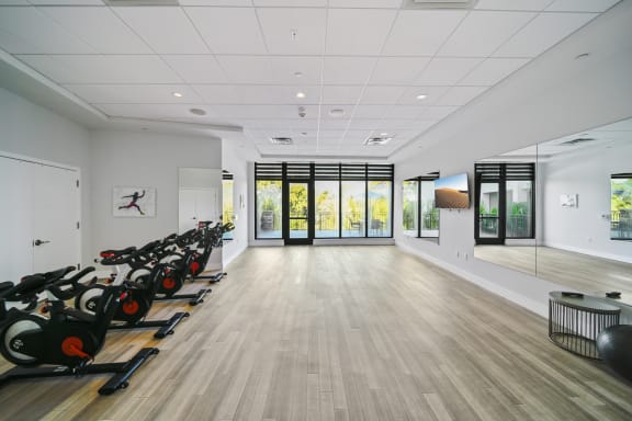 a workout room with a row of exercise bikes in it