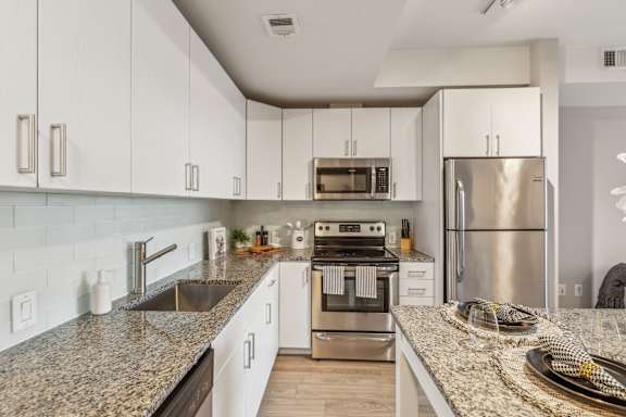 A kitchen with granite countertops and stainless steel appliances.