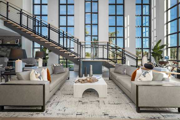 A living room with a staircase and two couches.