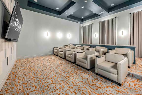 A conference room with a carpeted floor and a row of chairs.