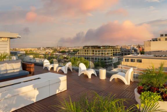 a roof top terrace with seating and a view of the city