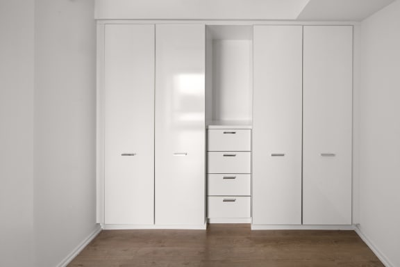 a wardrobe with white doors and drawers