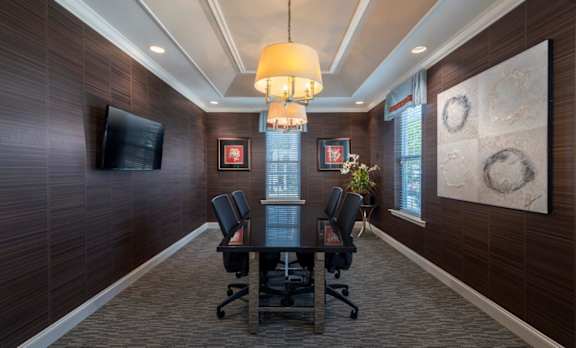 A conference room with a long table and chairs.