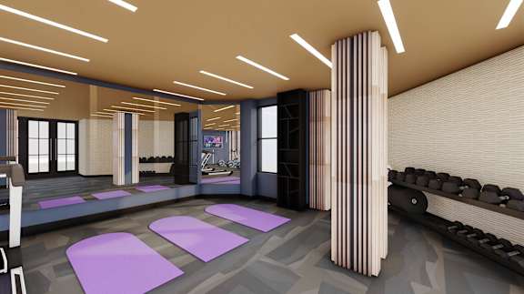 A modern room with purple mats on the floor and a row of black chairs.