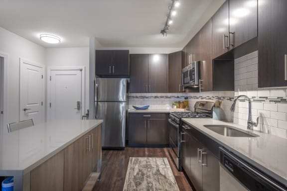 a kitchen with stainless steel appliances and white countertops