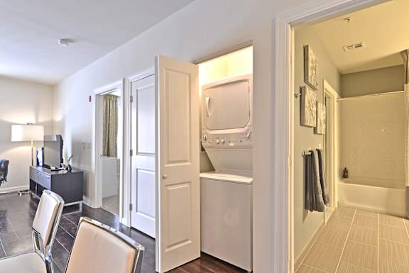 a living room with a refrigerator and a door to a laundry room