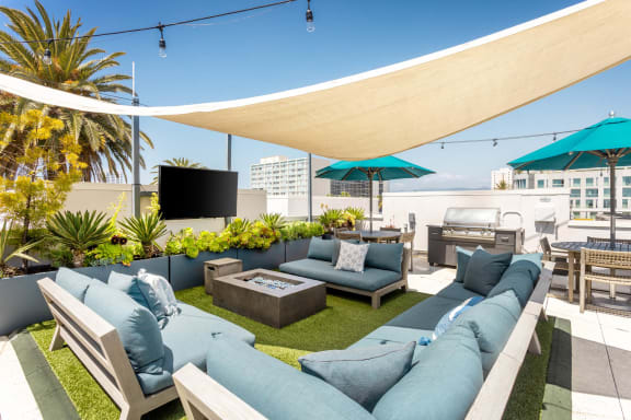 a rendering of a rooftop patio with couches and umbrellas