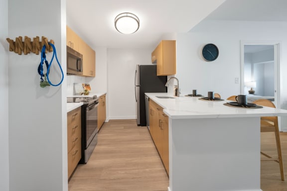 a kitchen with a white counter top and a black refrigerator