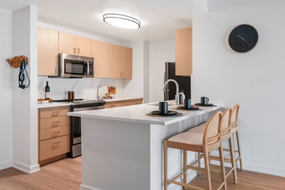 a kitchen with an island with two stools in front of it