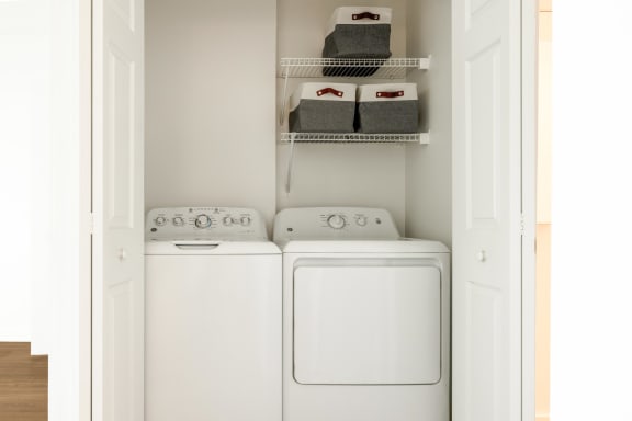 a white washer and dryer in a white laundry room