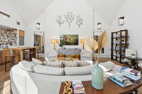A living room with a grey sofa, a wooden coffee table, and a large painting on the wall.