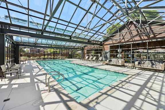 A large indoor swimming pool with a glass ceiling.