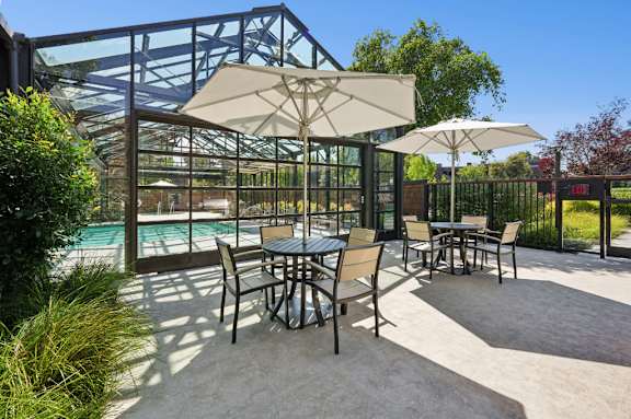 A patio with a table and chairs and an umbrella.