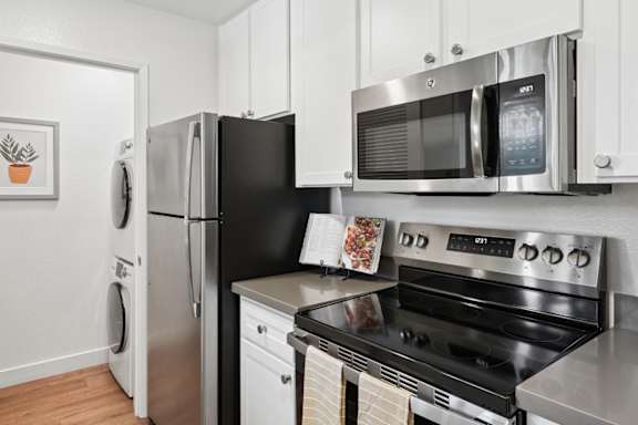 A black microwave oven is mounted on a white wall.