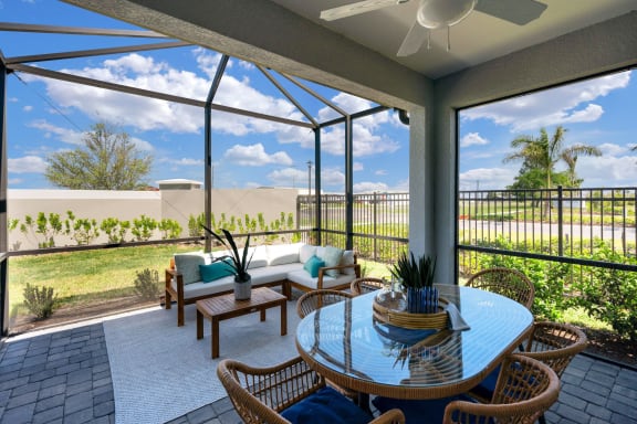 a patio with a table and chairs under a glass roof at Marisol, Bradenton FL