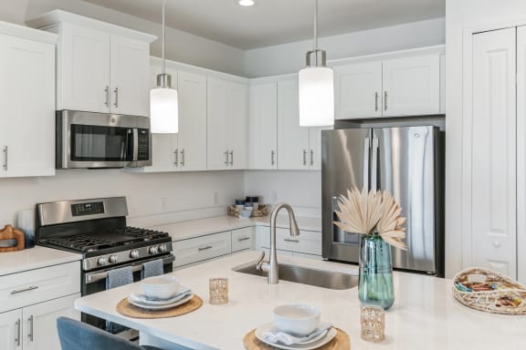 a kitchen with white cabinets and stainless steel appliances at Marisol, Bradenton Florida