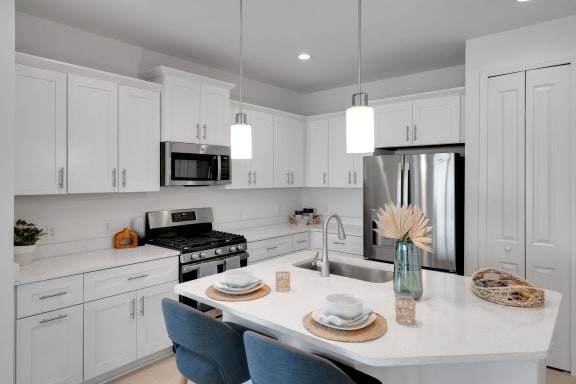 a kitchen with white cabinets and a marble counter top at Marisol, Florida