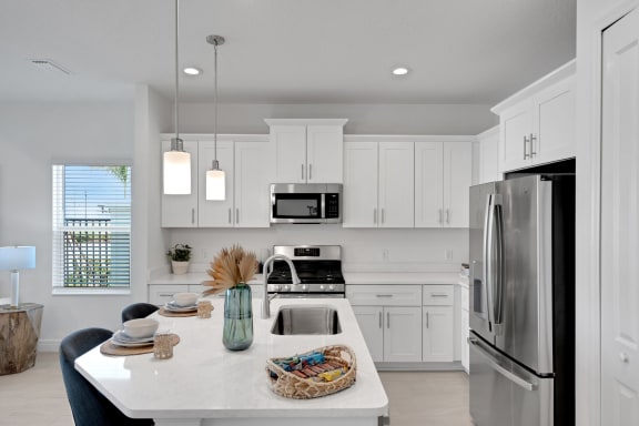 a white kitchen with stainless steel appliances and white cabinets at Marisol, Florida
