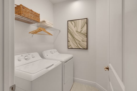 a laundry room with a washer and dryer and a painting on the wall at Marisol, Bradenton 34211