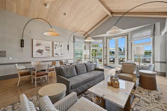 A modern living room with a large grey sofa and a wooden ceiling.