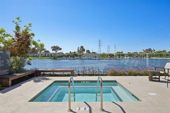A pool with a ladder and a bench next to a lake.