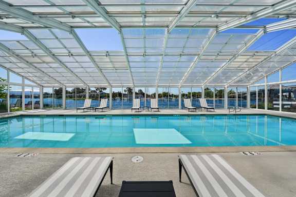 A large swimming pool under a glass roof.