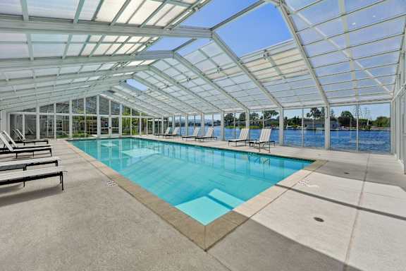 A large indoor swimming pool with a glass ceiling.