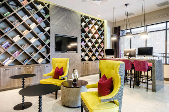 A modern living room with a yellow chair and a black table.