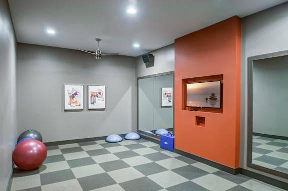 A room with a red ball, a mirror, and pictures on the wall.
