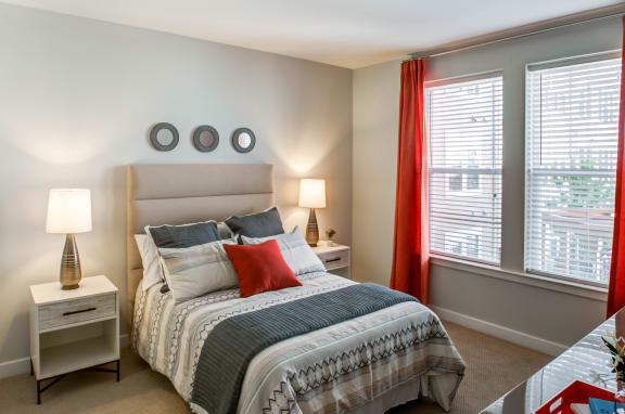 a bedroom with a bed and two windows
