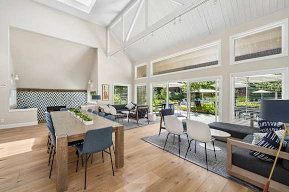 A modern dining room with a wooden table and chairs.