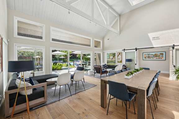 A dining room with a long wooden table and chairs.