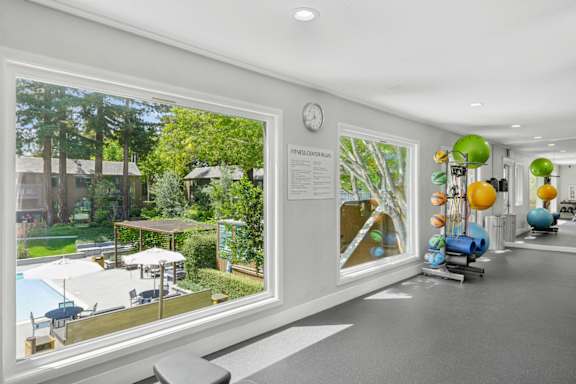A room with a large window overlooking a pool and trees.