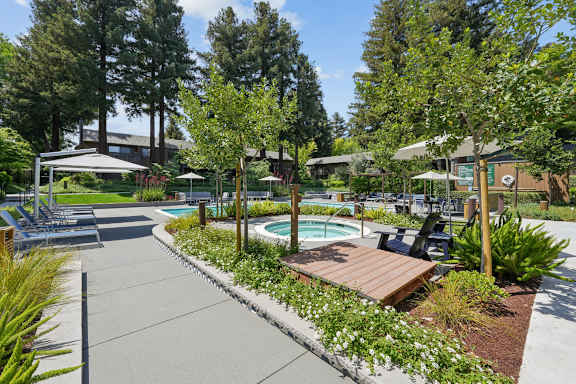 A pool area with a hot tub and a wooden bench.