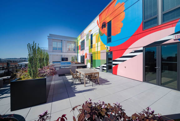 a patio with a table and chairs in front of a building