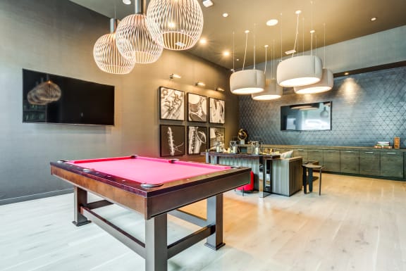 a billiards room with a pool table and a bar