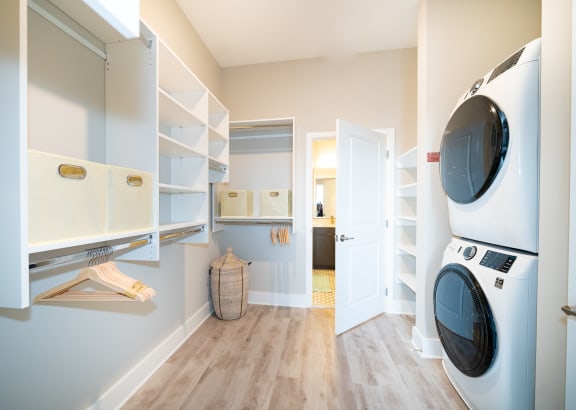 a washer and dryer in a laundry room with a door to a bathroom