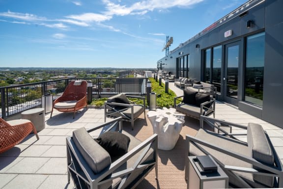 a roof top patio with furniture and a view of the city