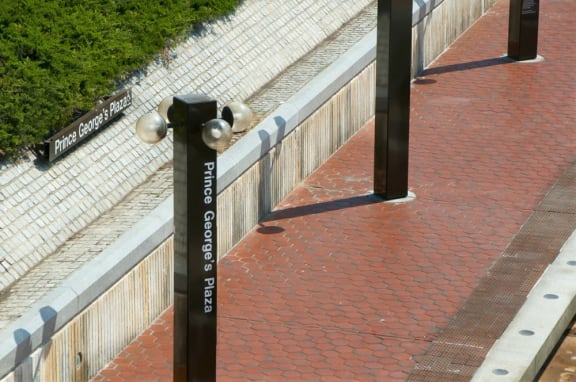 a parking meter on a sidewalk next to a fence
