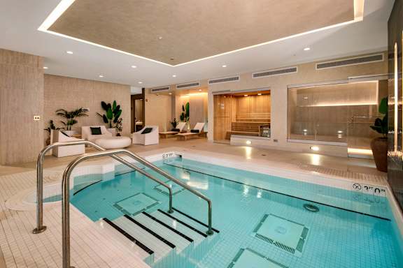 A large indoor swimming pool with a metal ladder.