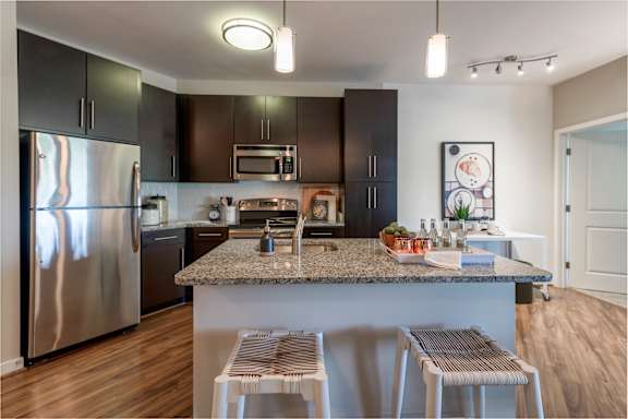 A kitchen with a granite countertop and stainless steel appliances.