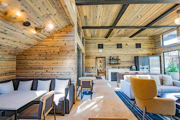 A living room with a wooden ceiling and a white couch.