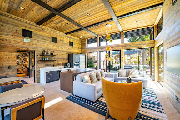 A modern living room with a wooden ceiling and a fireplace.