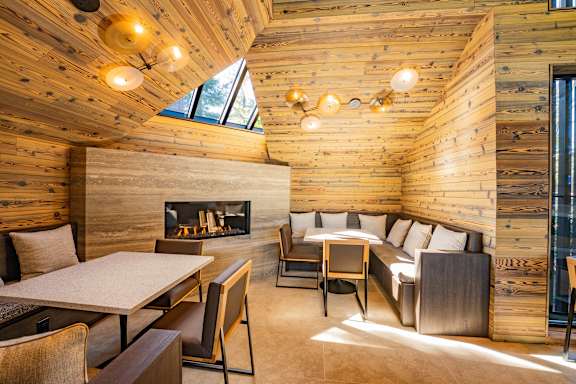 A wooden room with a fireplace and a table with chairs.