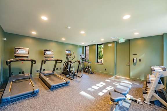 A gym with treadmills, exercise bikes, and other equipment.