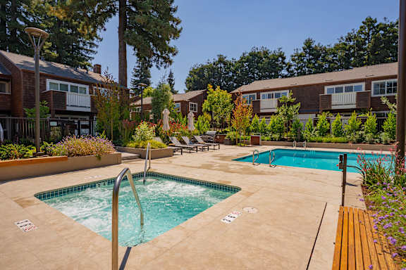 A small pool with a slide in the middle of a courtyard.