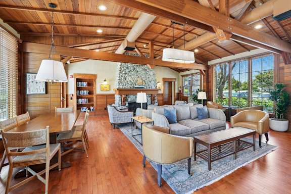 A large, well-lit living room with wooden floors and furniture.