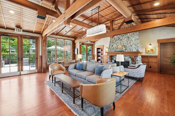 A living room with a stone fireplace and wood floors.