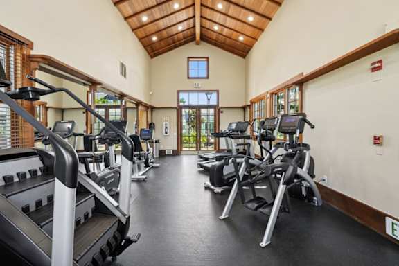 A gym with treadmills and elliptical machines.